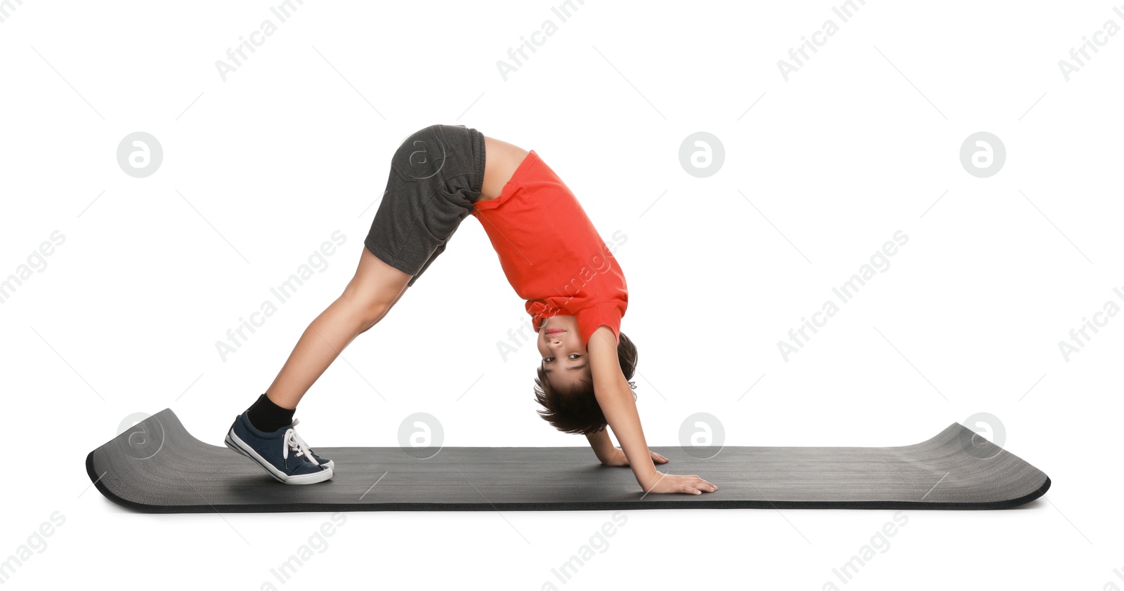 Photo of Boy exercising on fitness mat against white background. Sport activity