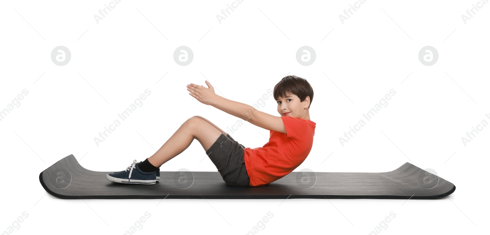 Photo of Boy exercising on fitness mat against white background. Sport activity