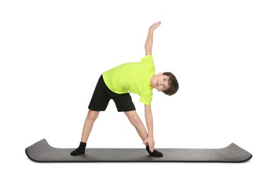 Photo of Boy exercising on fitness mat against white background. Sport activity