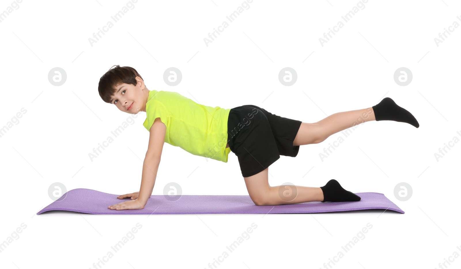 Photo of Boy exercising on fitness mat against white background. Sport activity