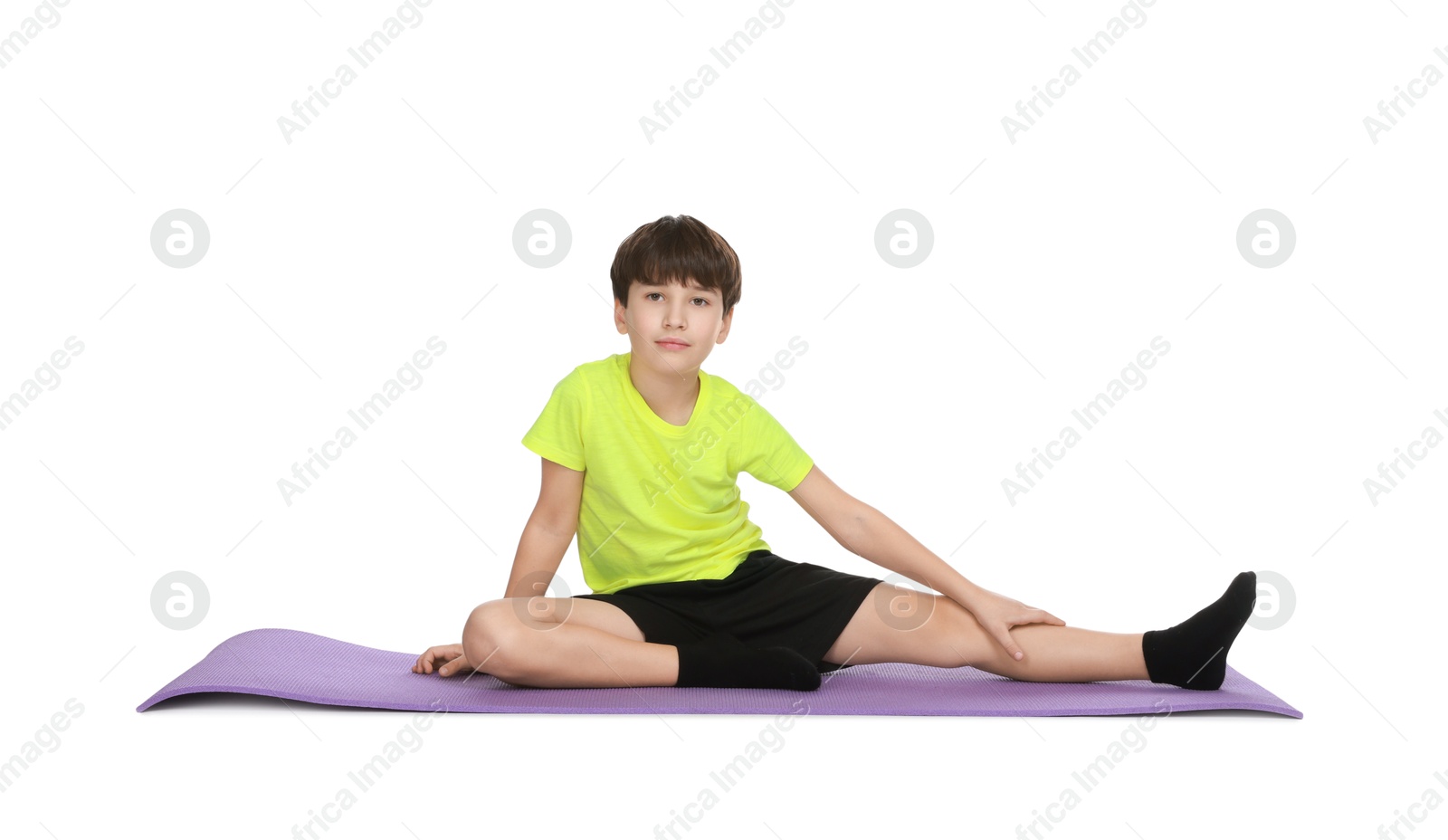 Photo of Boy exercising on fitness mat against white background. Sport activity