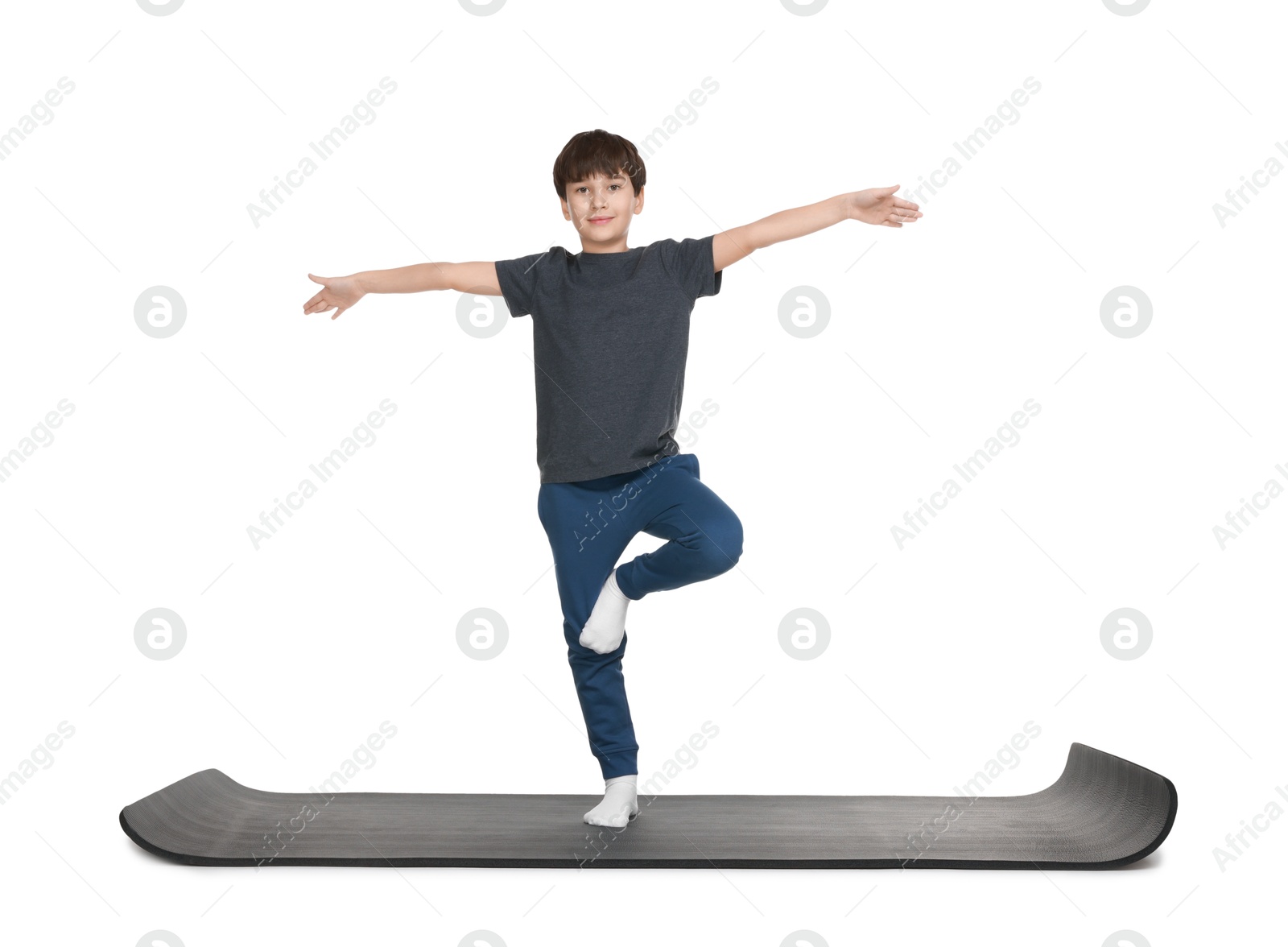 Photo of Boy exercising on fitness mat against white background. Sport activity