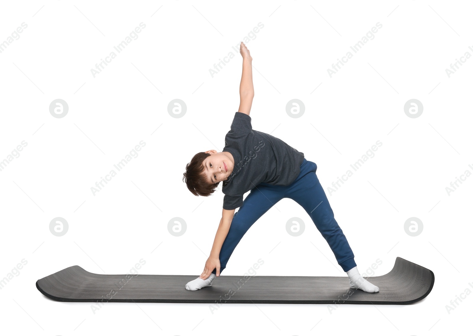 Photo of Boy exercising on fitness mat against white background. Sport activity