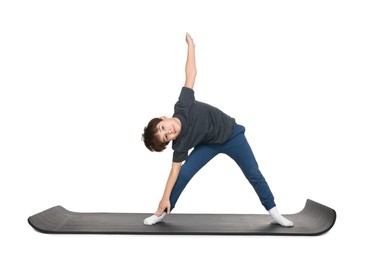 Photo of Boy exercising on fitness mat against white background. Sport activity