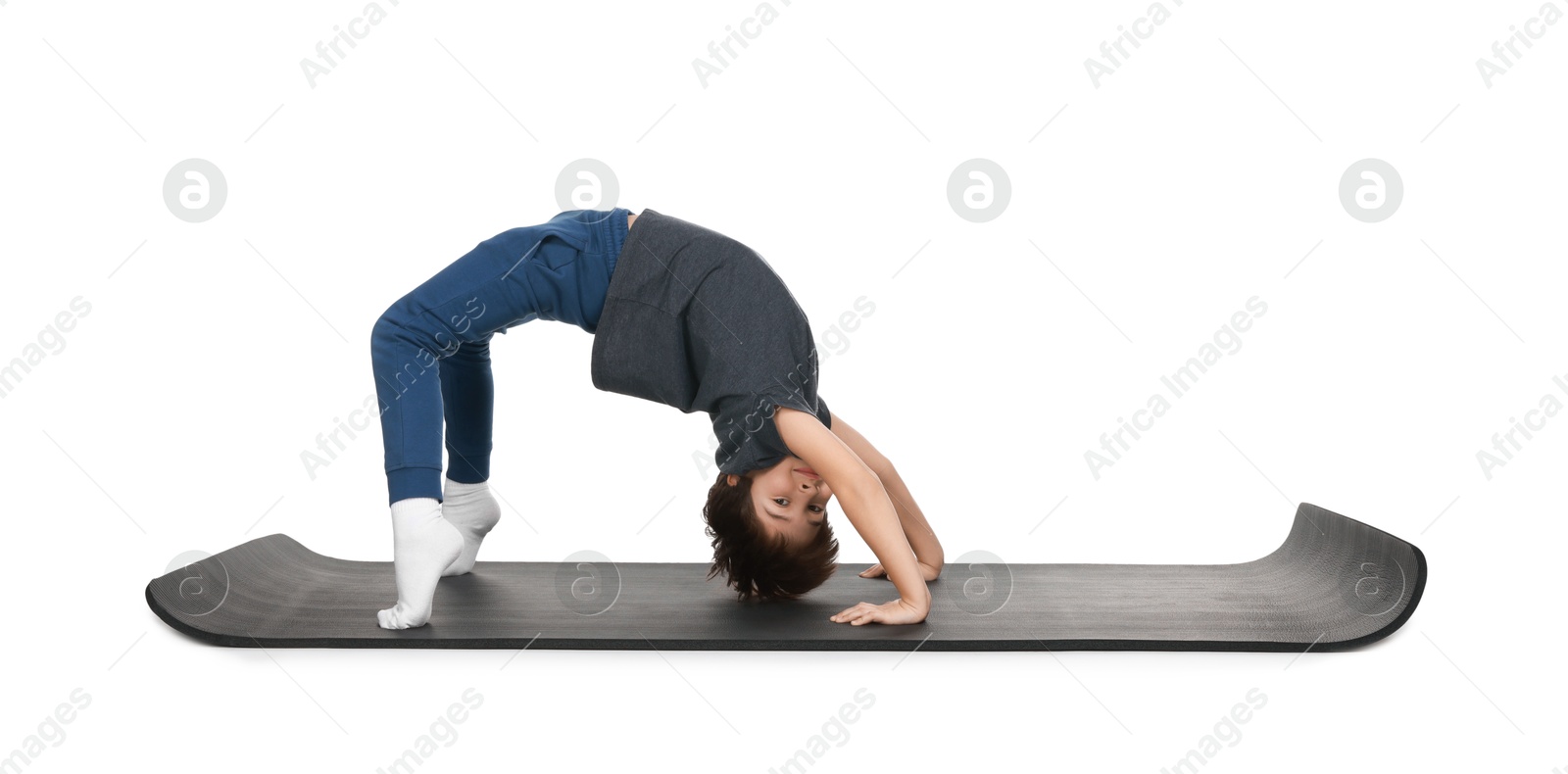 Photo of Boy exercising on fitness mat against white background. Sport activity