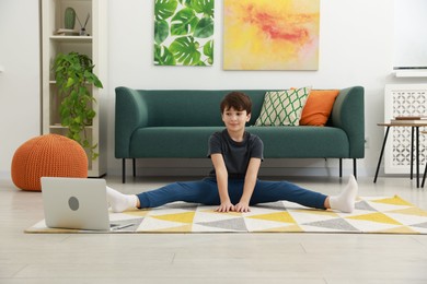 Photo of Boy having training with online coach via laptop at home