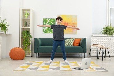 Photo of Boy having training with online coach via laptop at home