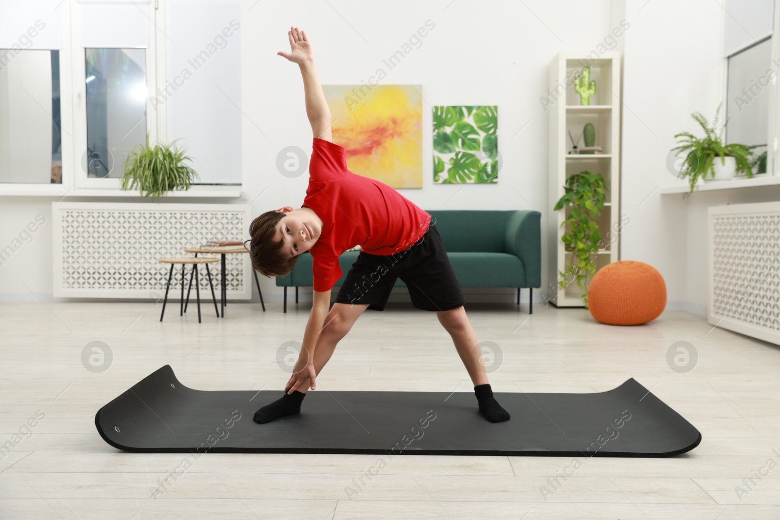 Photo of Boy doing exercise on fitness mat at home. Sport activity