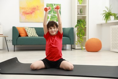 Photo of Boy training with dumbbells at home. Sport activity