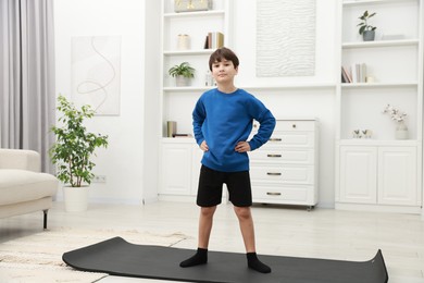 Photo of Boy doing exercise on fitness mat at home. Sport activity