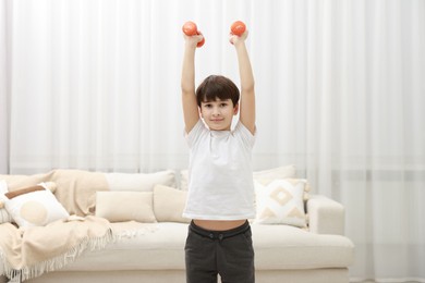 Photo of Boy training with dumbbells at home. Sport activity