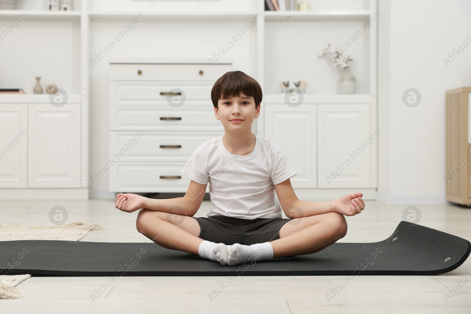 Photo of Boy doing exercise on fitness mat at home. Sport activity