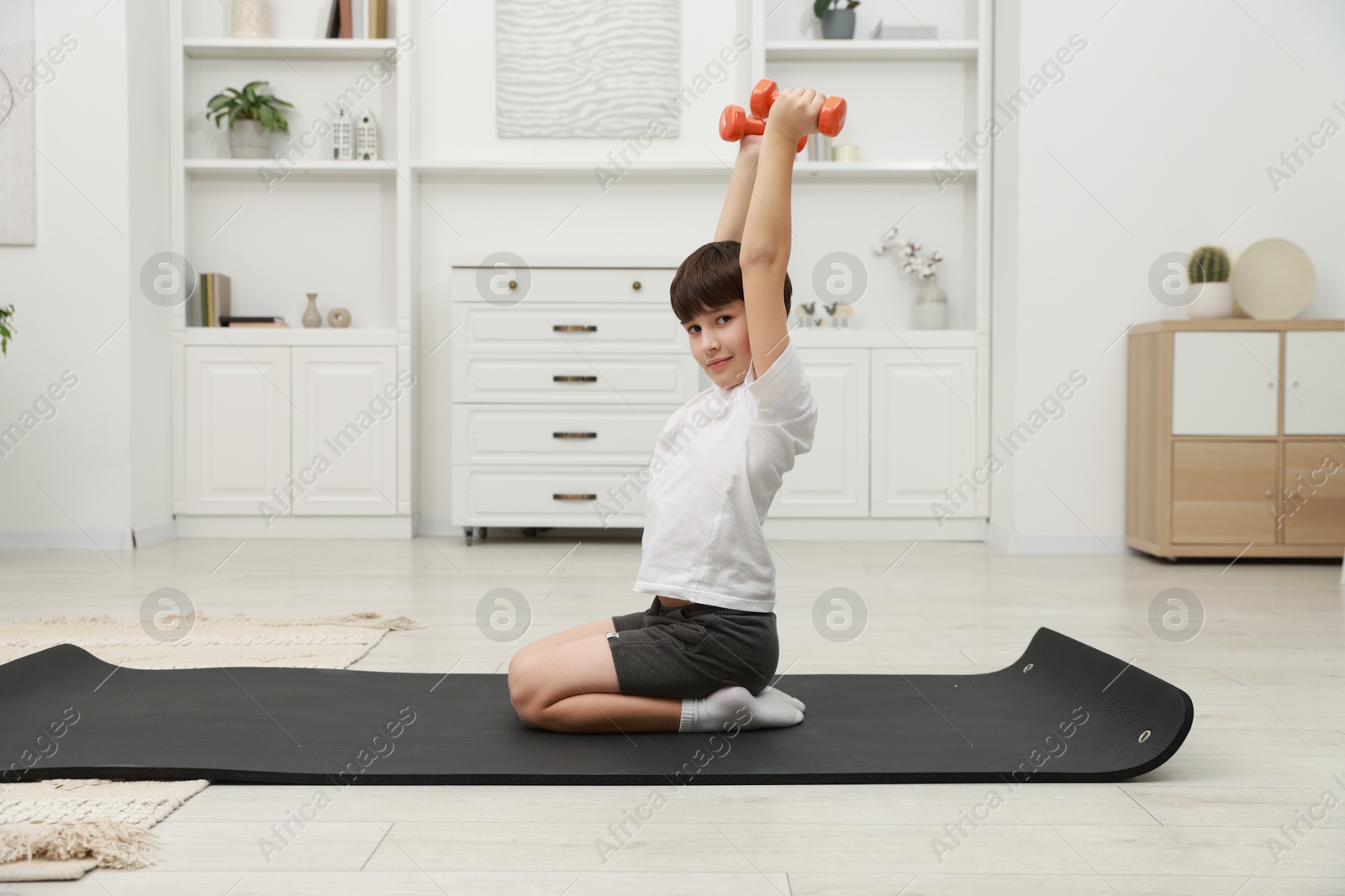 Photo of Boy training with dumbbells at home. Sport activity