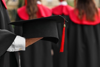 Photo of Student with graduation hat at ceremony outdoors, selective focus