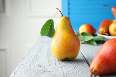 Photo of Ripe juicy pears on grey wooden table, selective focus