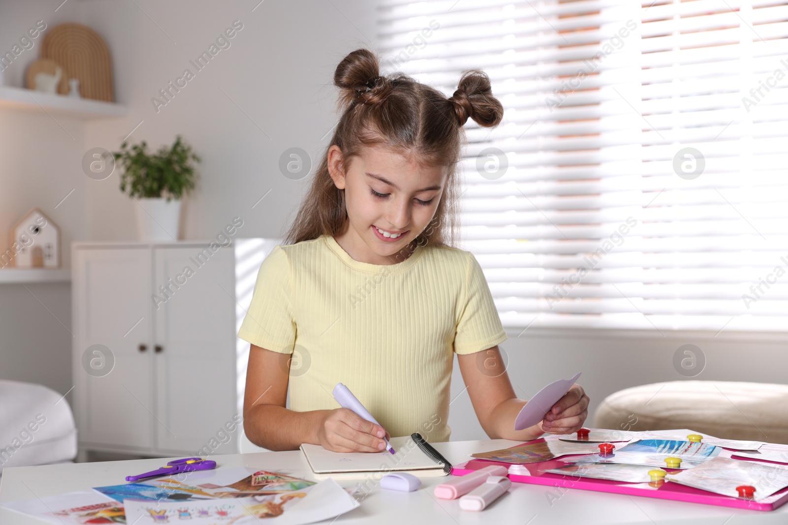 Photo of Creating vision board. Girl drawing something with violet marker at light table indoors