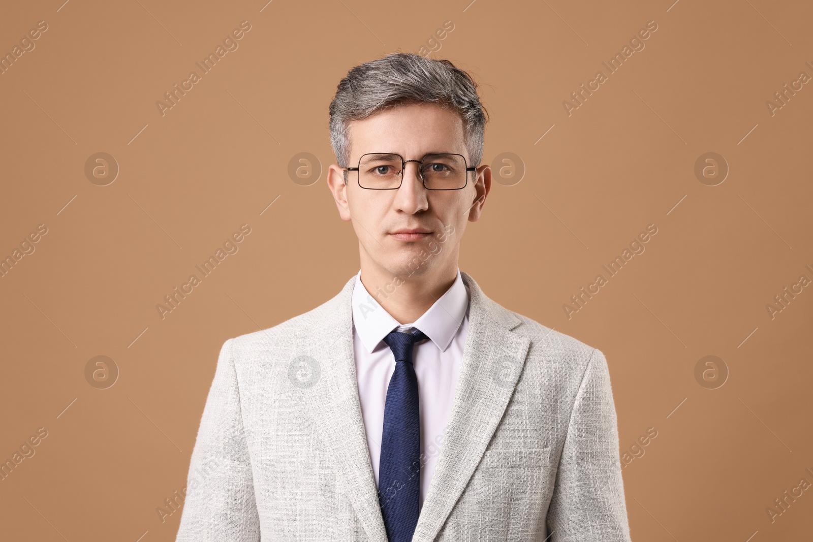 Photo of Portrait of businessman in glasses on brown background