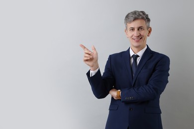 Photo of Portrait of businessman on light grey background, space for text