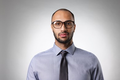 Portrait of businessman in glasses on light gray background