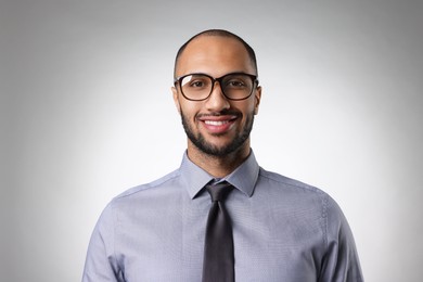 Portrait of businessman in glasses on light gray background