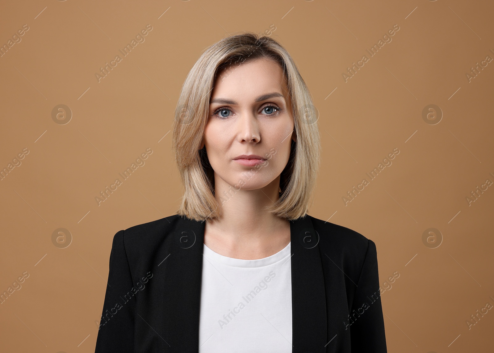 Photo of Portrait of businesswoman in jacket on beige background