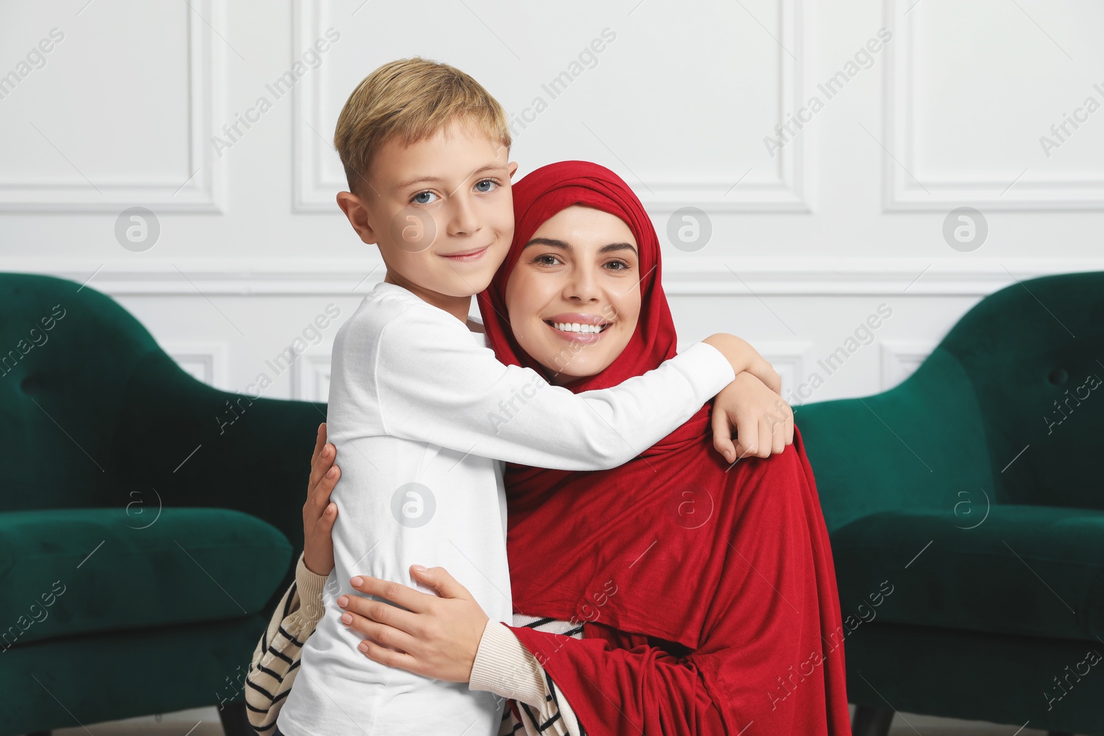 Photo of Muslim woman and her son spending time together at home