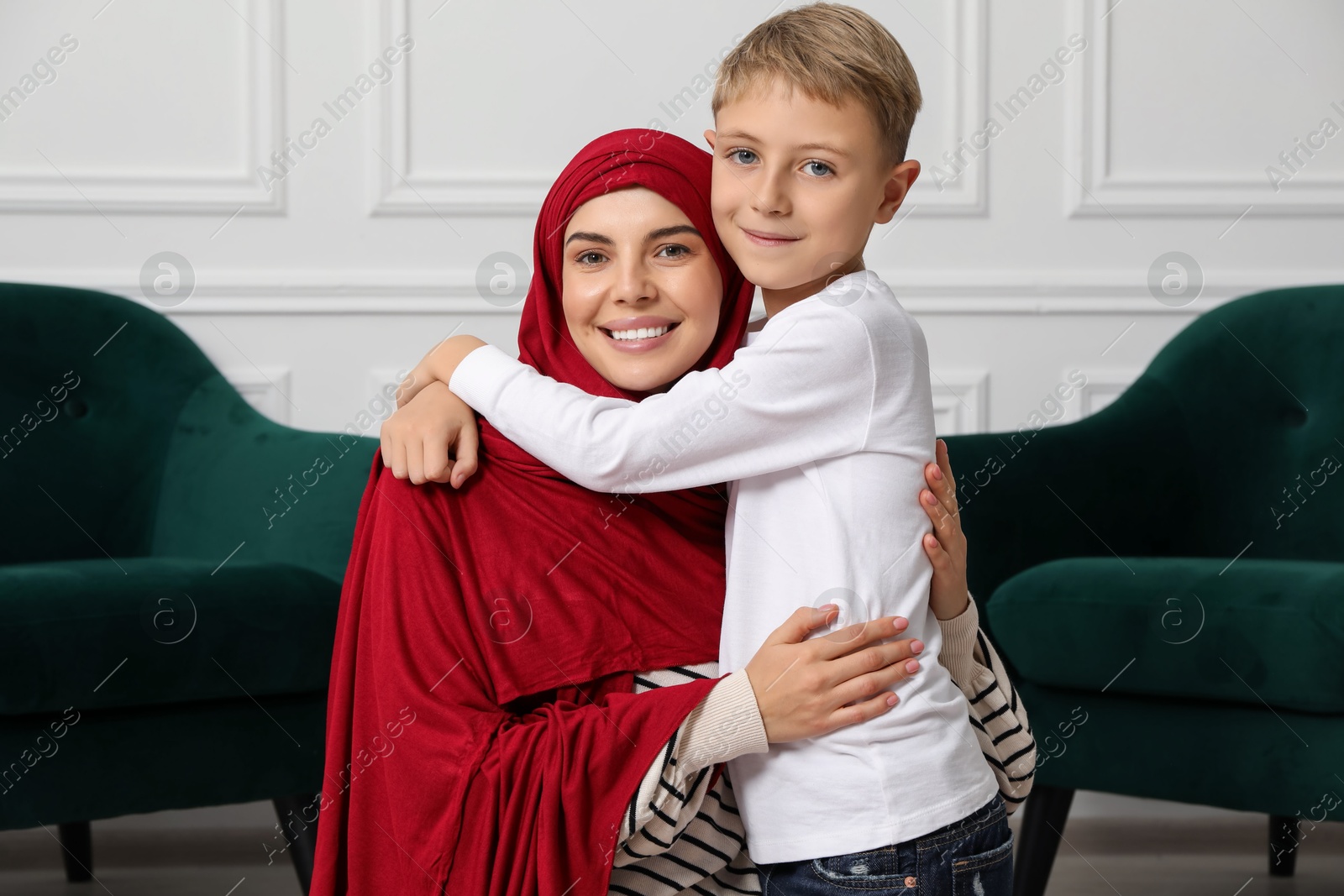 Photo of Muslim woman and her son spending time together at home