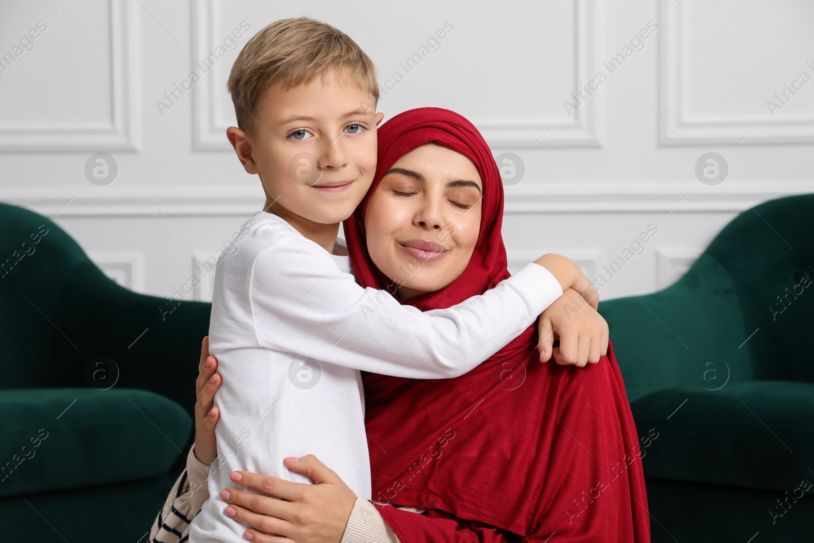 Photo of Muslim woman and her son spending time together at home