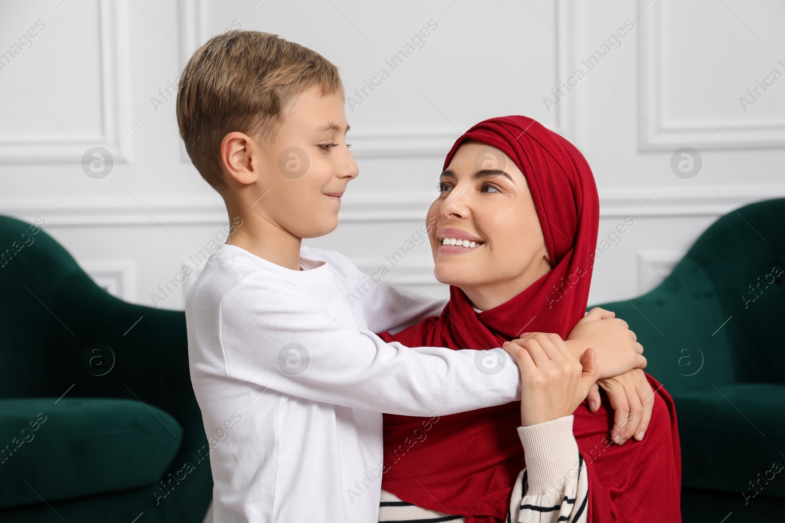 Photo of Muslim woman and her son spending time together at home