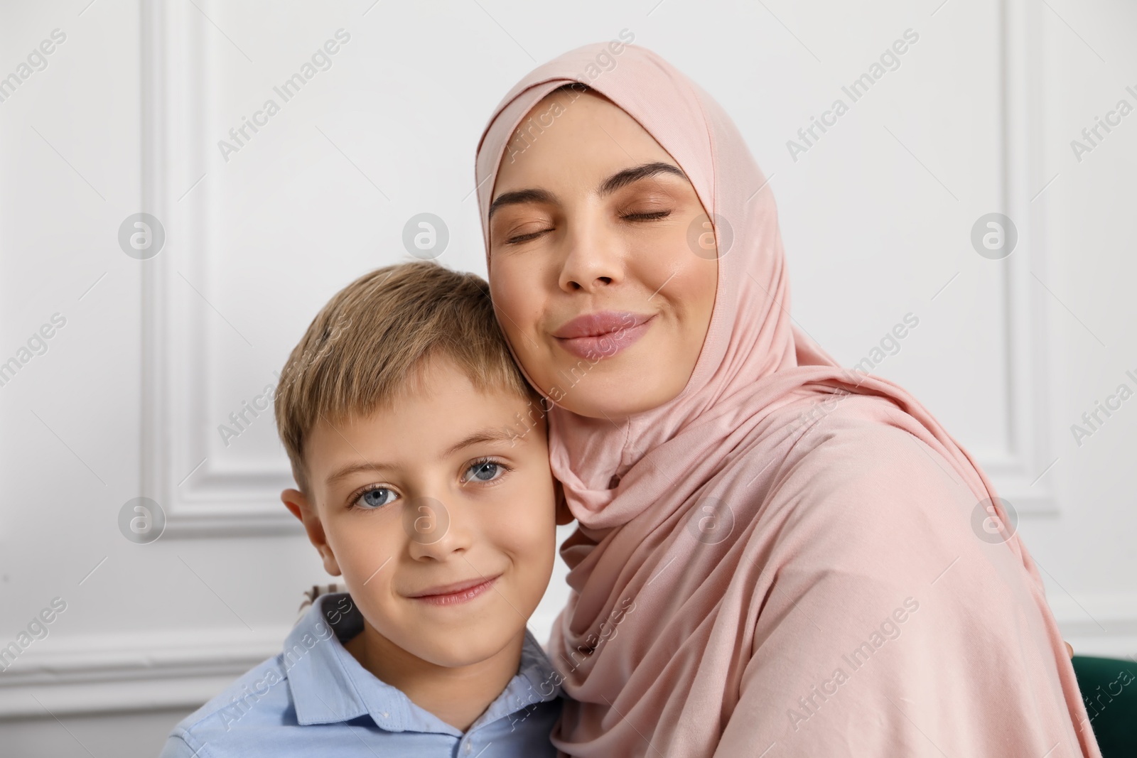 Photo of Muslim woman and her son spending time together at home