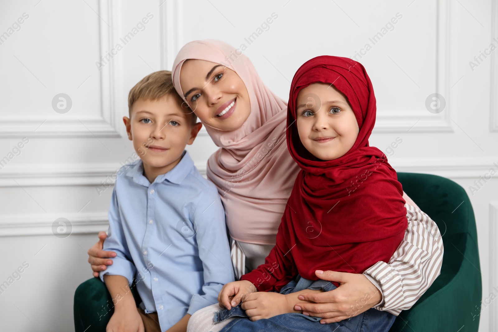 Photo of Muslim woman and her children spending time together at home