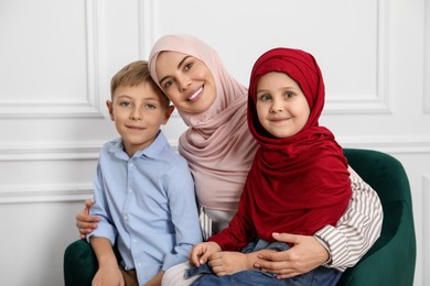 Photo of Muslim woman and her children spending time together at home