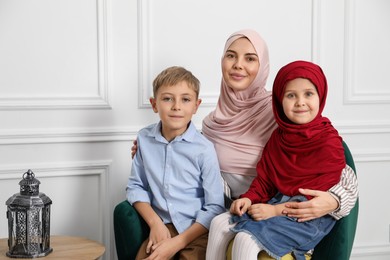 Photo of Muslim woman and her children spending time together at home