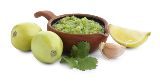 Photo of Delicious homemade green salsa and ingredients isolated on white