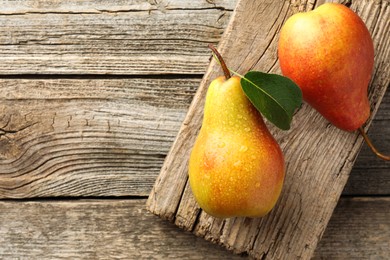 Photo of Ripe juicy pears on wooden table, top view. Space for text