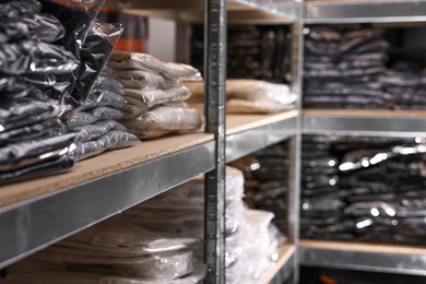 Photo of Many different types of fabric on shelves in professional atelier