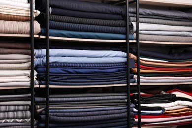 Photo of Many different types of fabric on shelves in professional atelier