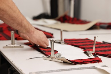 Photo of Man working at white table in professional workshop, closeup