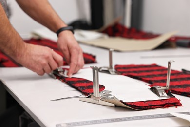 Photo of Man working at white table in professional workshop, closeup