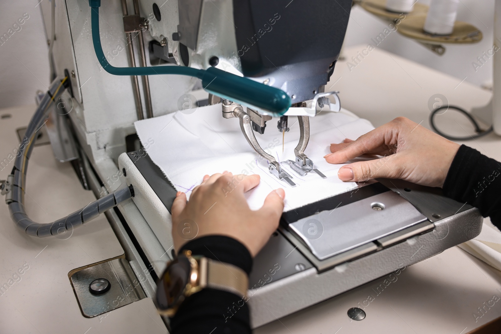 Photo of Woman working with sewing machine in professional workshop, closeup