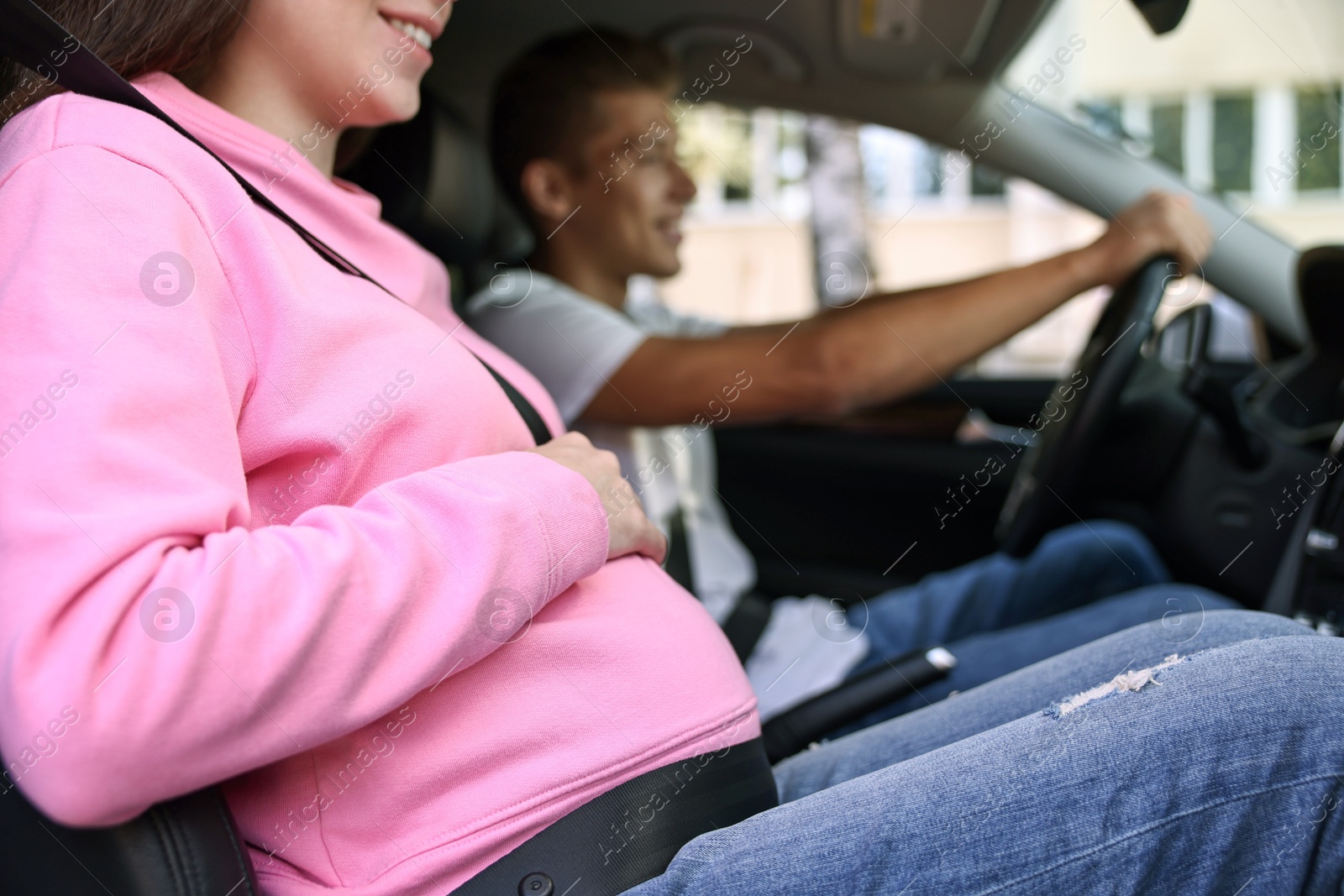 Photo of Smiling pregnant woman travelling with her husband by car, closeup