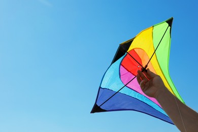 Photo of Man with bright kite against blue sky, closeup. Space for text