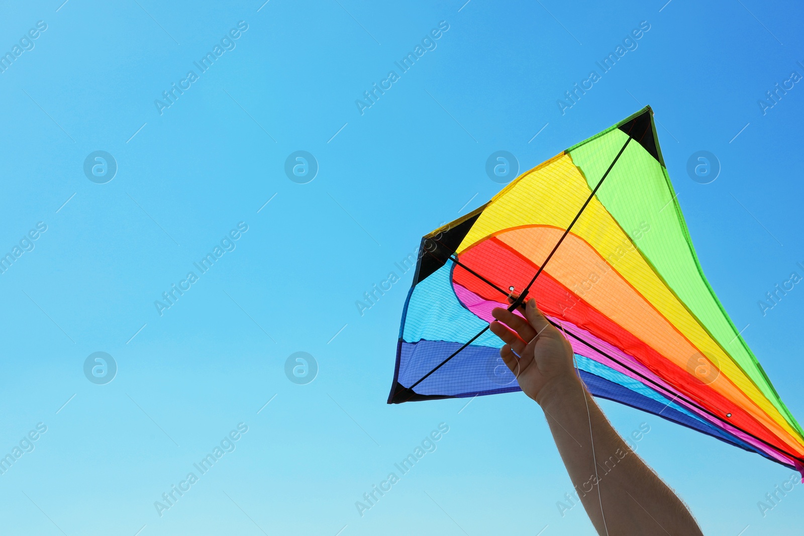 Man with bright kite against blue sky, closeup. Space for text Photo of Man with bright kite against blue sky, closeup. Space for text