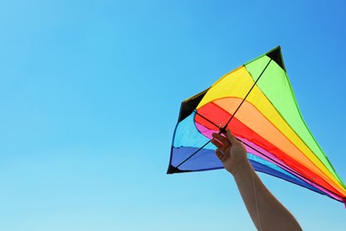 Photo of Man with bright kite against blue sky, closeup. Space for text