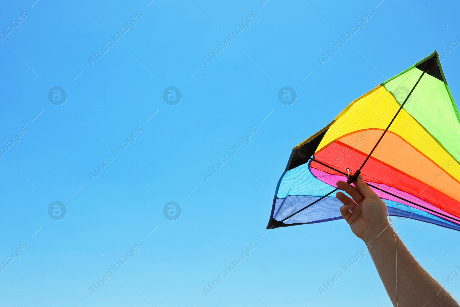 Man with bright kite against blue sky, closeup. Space for text Photo of Man with bright kite against blue sky, closeup. Space for text