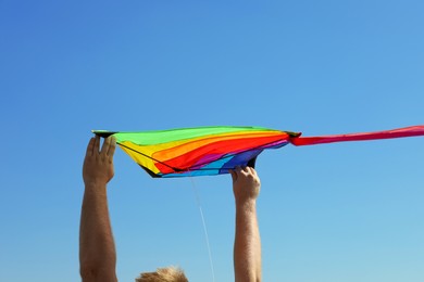 Photo of Man with kite against blue sky, closeup
