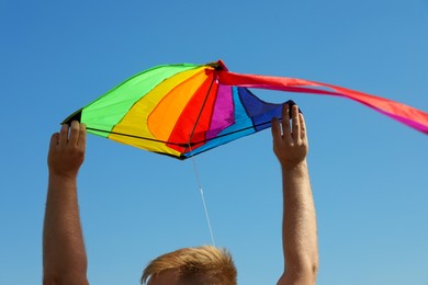 Photo of Man with kite against blue sky, closeup