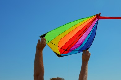 Photo of Man with kite against blue sky, closeup