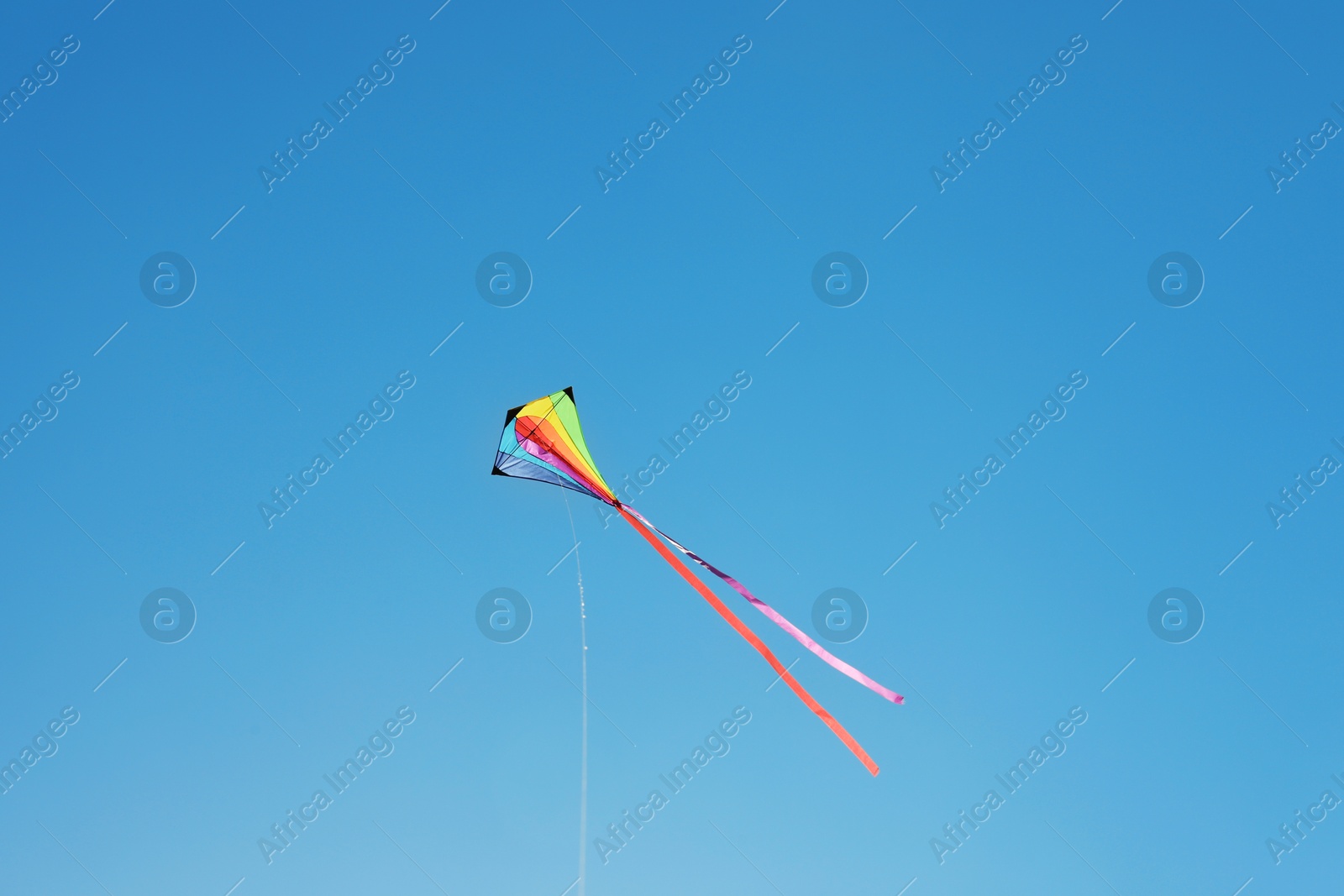One colorful kite flying in blue sky Photo of One colorful kite flying in blue sky