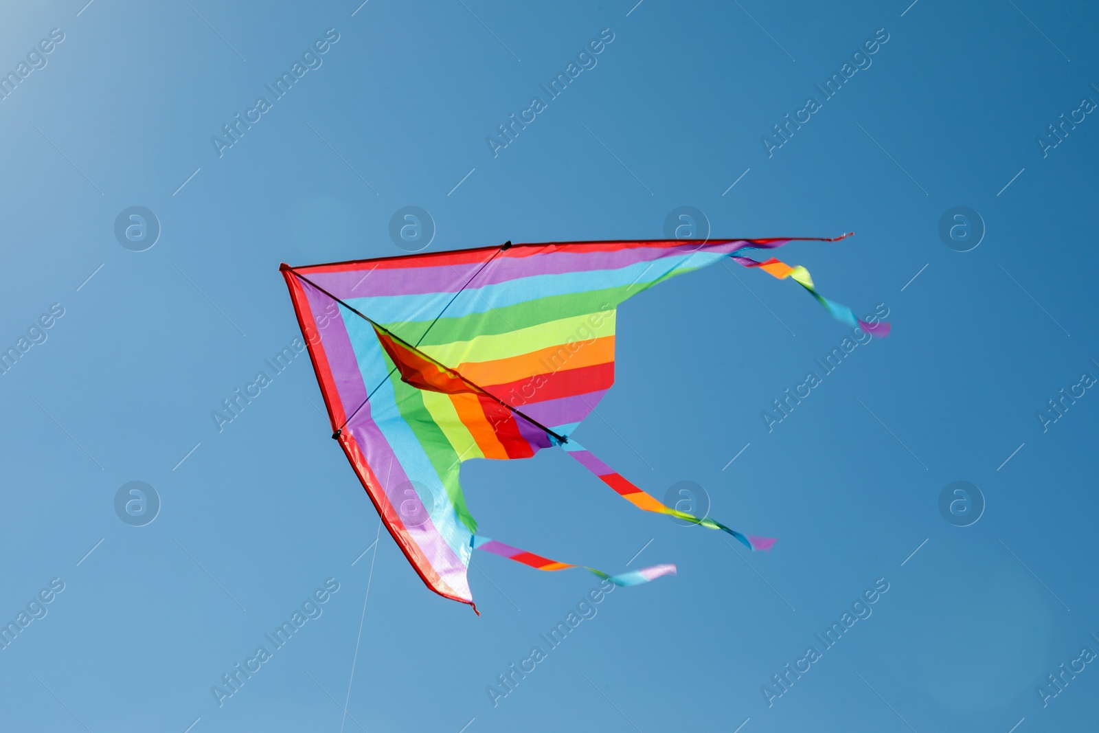 One colorful kite flying in blue sky Photo of One colorful kite flying in blue sky